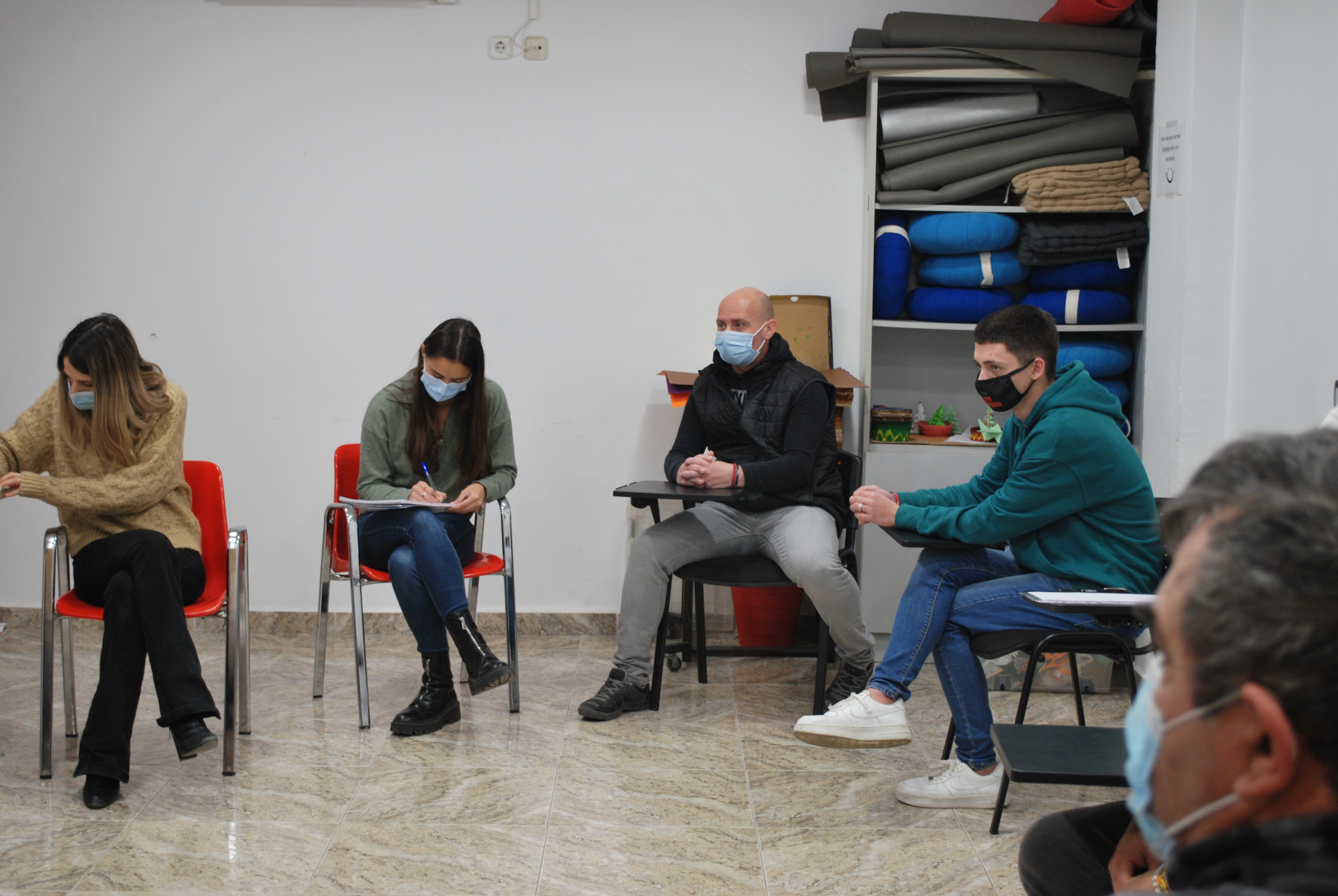 Un grupo de personas sentadas en sillas formando un círculo