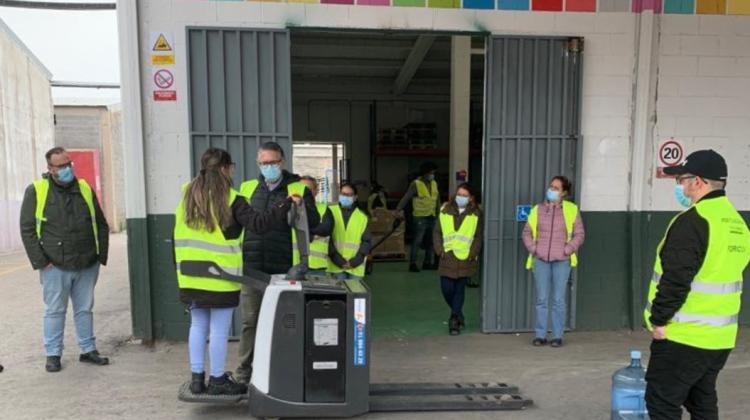 Un grupo de personas atendiendo a una demostración con una carretilla eléctrica